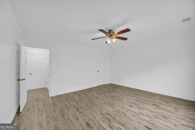 spare room featuring ceiling fan, ornamental molding, light wood finished floors, and baseboards