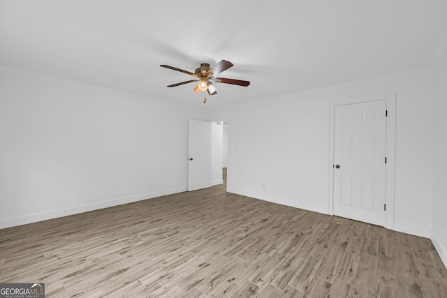 empty room featuring wood finished floors, a ceiling fan, baseboards, and ornamental molding