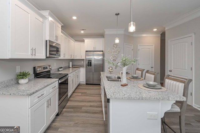 2871 Fareed, Douglasville, GA 30135 - kitchen featuring stainless steel appliances, a kitchen breakfast bar, ornamental molding, wood finished floors, and a center island with sink