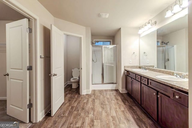 255 Dublin Way, Dallas, GA 30132 - full bath with a stall shower, wood finished floors, double vanity, toilet, and baseboards