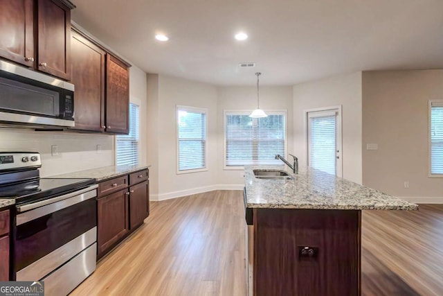 255 Dublin Way, Dallas, GA 30132 - kitchen featuring appliances with stainless steel finishes, a sink, light wood-style floors, baseboards, and light stone counters