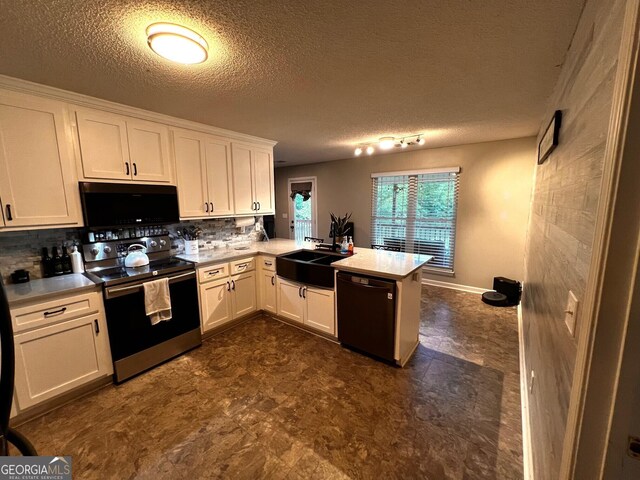 kitchen featuring black appliances, a sink, a peninsula, decorative backsplash, and white cabinets
