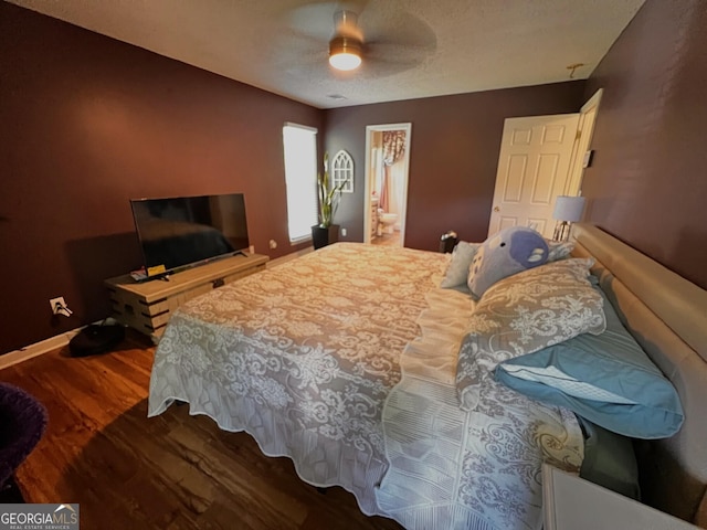 bedroom with wood finished floors, baseboards, ceiling fan, ensuite bath, and a textured ceiling