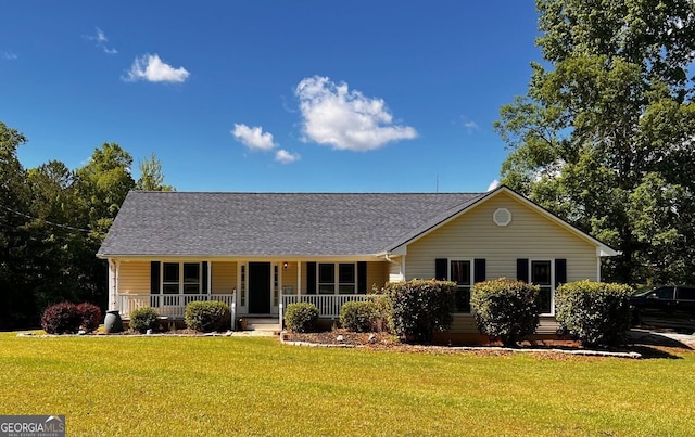 view of front of home with a porch, a front lawn, and roof with shingles