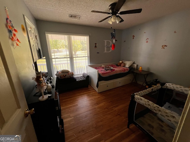 bedroom featuring wood finished floors, a textured ceiling, and ceiling fan