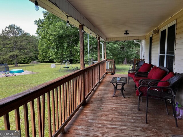 deck with a lawn, an outdoor hangout area, and view of scattered trees