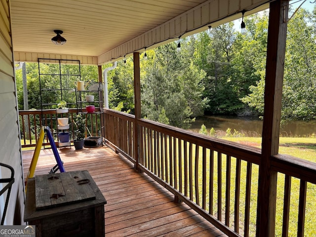 wooden deck featuring a water view and view of scattered trees