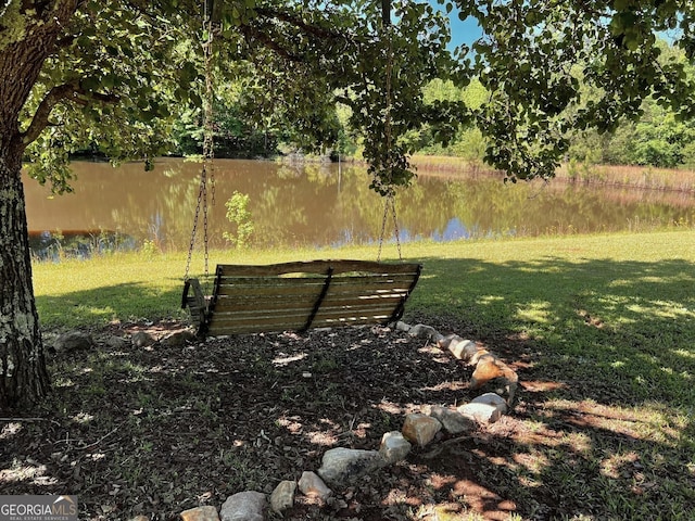 view of community featuring a water view and a lawn