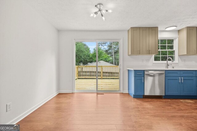 1355 Tucker Woods Dr, Norcross, GA 30093 - kitchen featuring stainless steel dishwasher, a chandelier, a textured ceiling, light countertops, and light wood finished floors