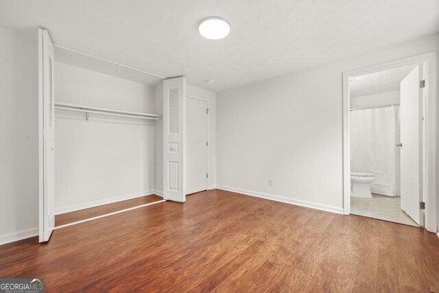 1355 Tucker Woods Dr, Norcross, GA 30093 - unfurnished bedroom featuring a closet, wood finished floors, and baseboards