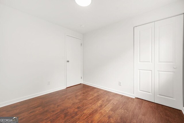 1355 Tucker Woods Dr, Norcross, GA 30093 - unfurnished bedroom with wood finished floors, baseboards, and a closet