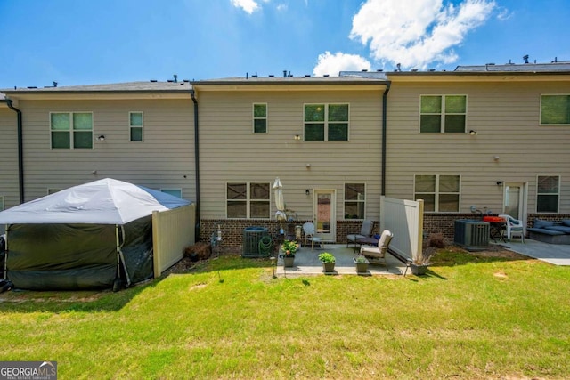 rear view of property featuring a patio area, brick siding, central air condition unit, and a lawn