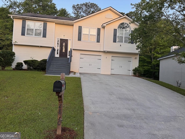 split foyer home with concrete driveway, a front yard, and an attached garage
