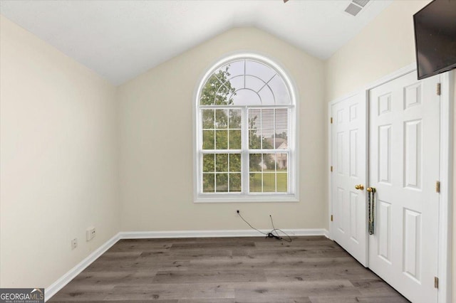 2880 Field Spring Dr, Lithonia, GA 30058 - unfurnished bedroom featuring lofted ceiling, wood finished floors, and baseboards