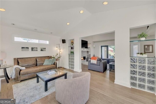 1420 Cortez Ln NE, Atlanta, GA 30319 - living room featuring lofted ceiling, light wood-type flooring, recessed lighting, and a lit fireplace