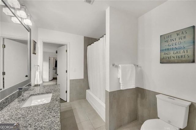 1420 Cortez Ln NE, Atlanta, GA 30319 - full bath featuring vanity, tile patterned floors, tile walls, wainscoting, and shower / tub combo