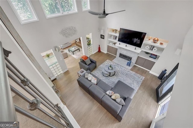 1420 Cortez Ln NE, Atlanta, GA 30319 - living room featuring a towering ceiling, plenty of natural light, a fireplace, and wood finished floors