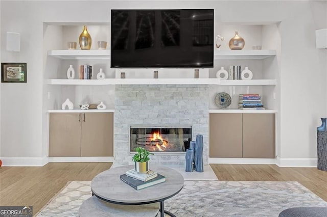 1420 Cortez Ln NE, Atlanta, GA 30319 - living area featuring wood finished floors, built in features, and a stone fireplace