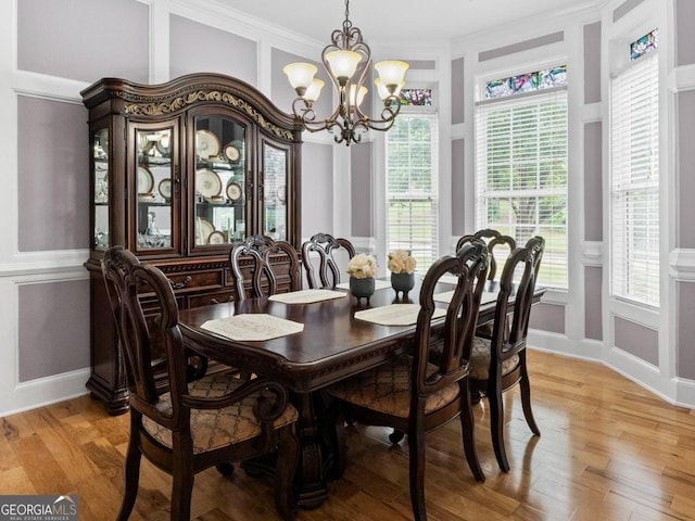 124 Belford Way, Locust Grove, GA 30233 - dining space featuring a chandelier, crown molding, a decorative wall, and light wood finished floors