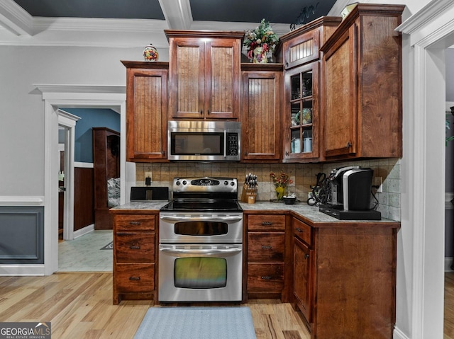 124 Belford Way, Locust Grove, GA 30233 - kitchen with appliances with stainless steel finishes, light wood-type flooring, backsplash, crown molding, and light countertops
