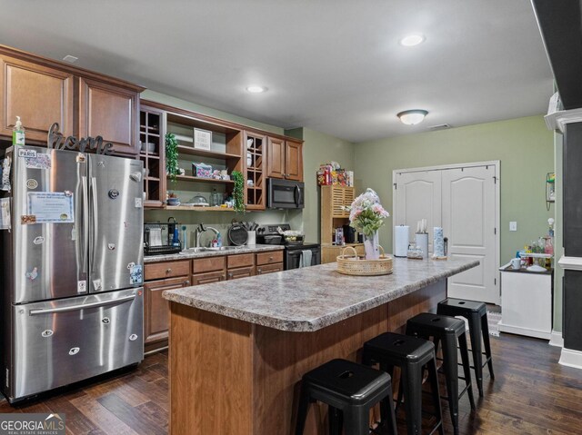 124 Belford Way, Locust Grove, GA 30233 - kitchen with black appliances, a breakfast bar, dark wood finished floors, light countertops, and a center island