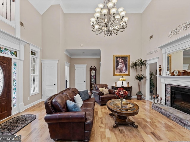 124 Belford Way, Locust Grove, GA 30233 - living area featuring wood finished floors, a towering ceiling, a chandelier, a fireplace, and crown molding