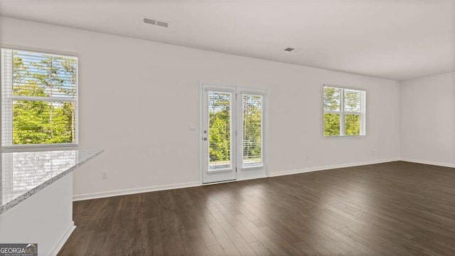 unfurnished room featuring dark wood-style floors and baseboards