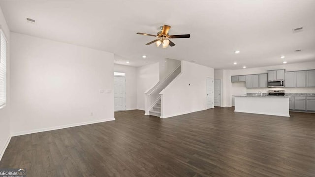 unfurnished living room with recessed lighting, dark wood-style flooring, stairway, ceiling fan, and baseboards