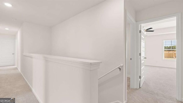 corridor with light colored carpet, an upstairs landing, baseboards, and recessed lighting