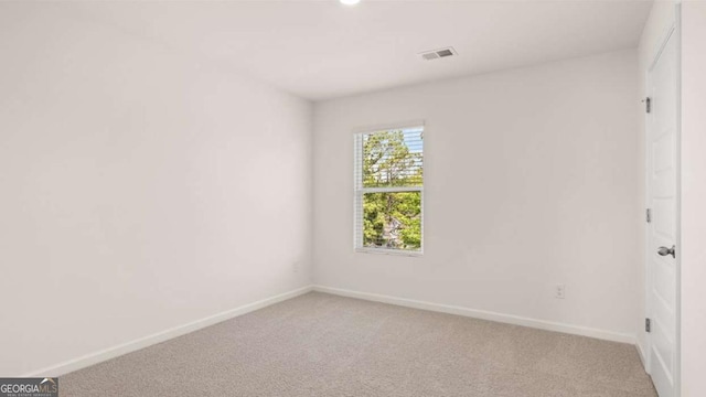 empty room featuring light colored carpet and baseboards