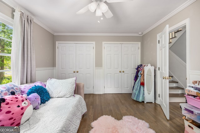 504 Kingswood Ln NW, Atlanta, GA 30305 - bedroom with two closets, crown molding, wood finished floors, a wainscoted wall, and a ceiling fan