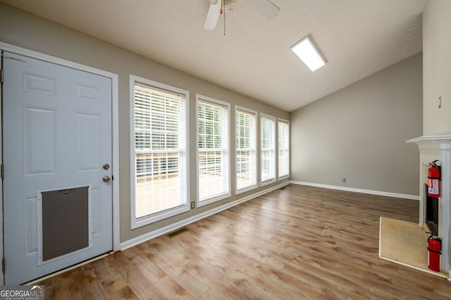 6391 Compass Dr, Flowery Branch, GA 30542 - unfurnished living room with vaulted ceiling, wood finished floors, ceiling fan, and a premium fireplace