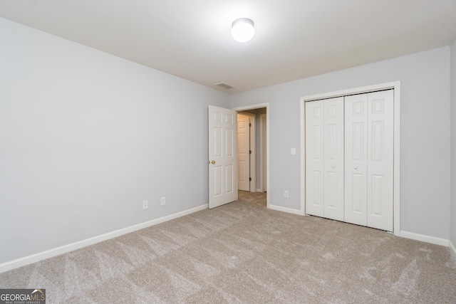 unfurnished bedroom with carpet flooring, baseboards, and a closet