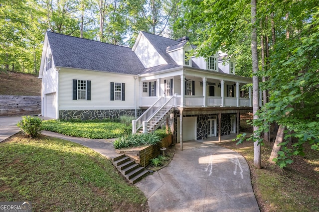 view of front of property featuring concrete driveway, a garage, a porch, and stairway