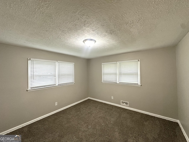1889 Silver Creek Dr, Austell, GA 30168 - spare room with a textured ceiling, dark colored carpet, and baseboards