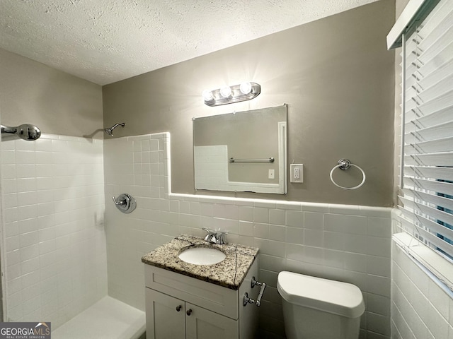 1889 Silver Creek Dr, Austell, GA 30168 - full bathroom featuring a textured ceiling, tile walls, a tile shower, toilet, and vanity