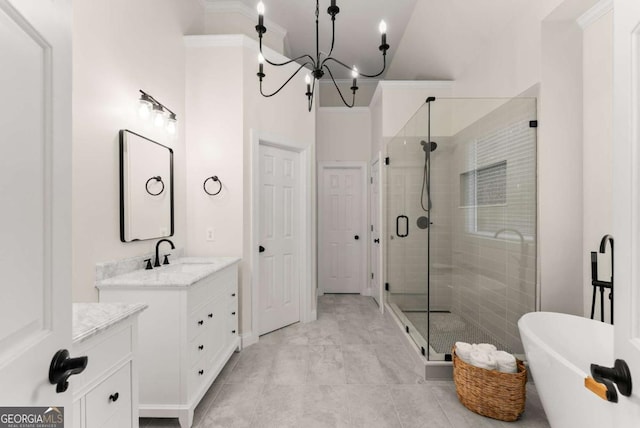 bathroom with a shower stall, a freestanding tub, vanity, a chandelier, and ornamental molding