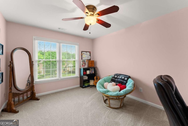 sitting room featuring carpet floors, baseboards, and ceiling fan