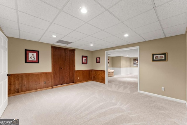 finished below grade area featuring carpet flooring, wainscoting, a drop ceiling, and recessed lighting