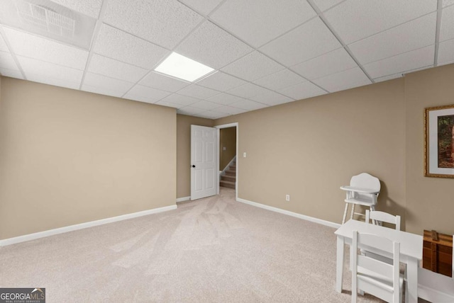 unfurnished room featuring carpet, baseboards, a paneled ceiling, and stairs