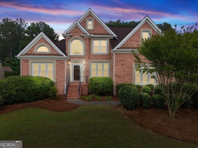 traditional-style home with a front yard and brick siding