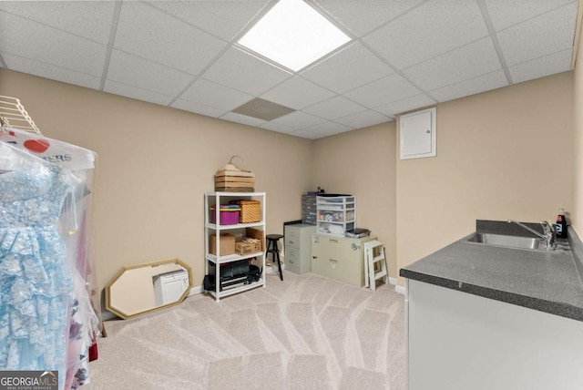 recreation room with a sink, a drop ceiling, and carpet floors