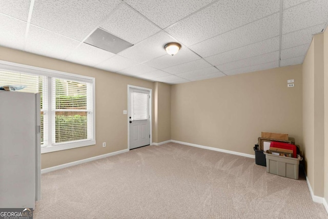 carpeted empty room featuring baseboards and a paneled ceiling