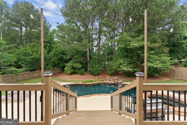view of pool featuring a fenced backyard, a wooden deck, a patio, and view of scattered trees