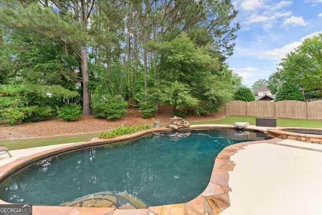 view of swimming pool with fence, a patio area, and a pool with connected hot tub