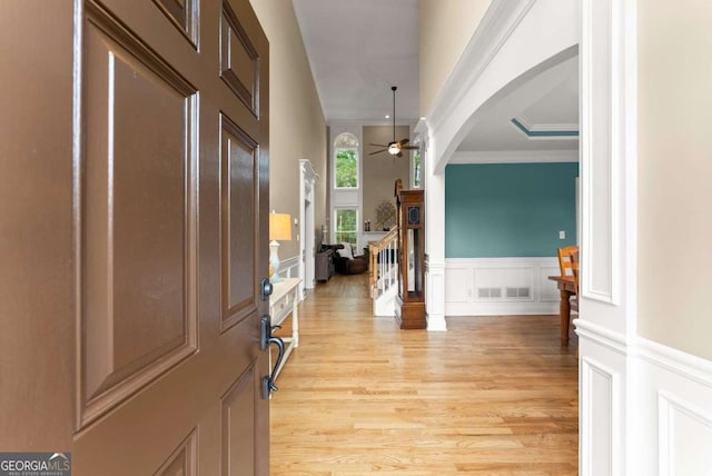 1721 Mulberry Lake Dr, Dacula, GA 30019 - entryway with a decorative wall, crown molding, arched walkways, light wood finished floors, and a ceiling fan