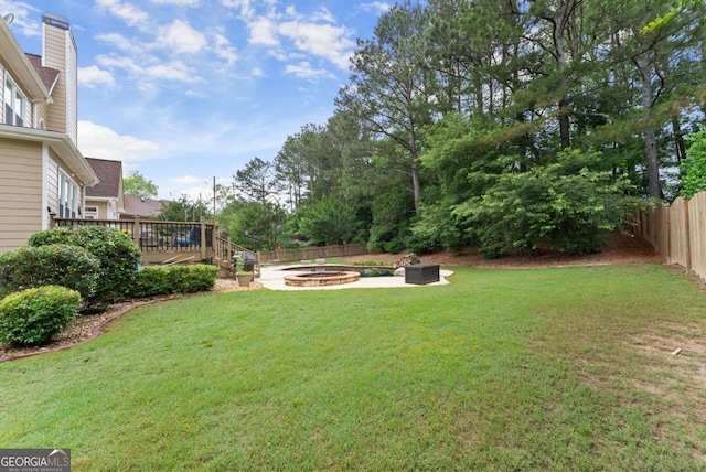 view of yard featuring an outdoor fire pit and a deck