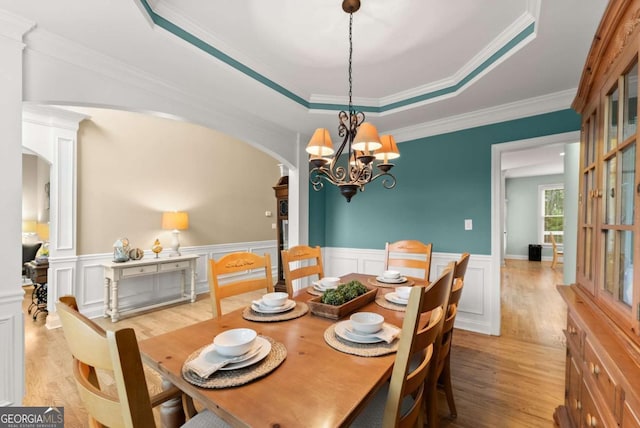 1721 Mulberry Lake Dr, Dacula, GA 30019 - dining area with arched walkways, light wood finished floors, a tray ceiling, a chandelier, and a wainscoted wall