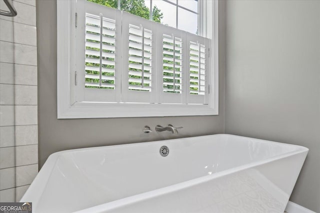 full bathroom with healthy amount of natural light and a soaking tub