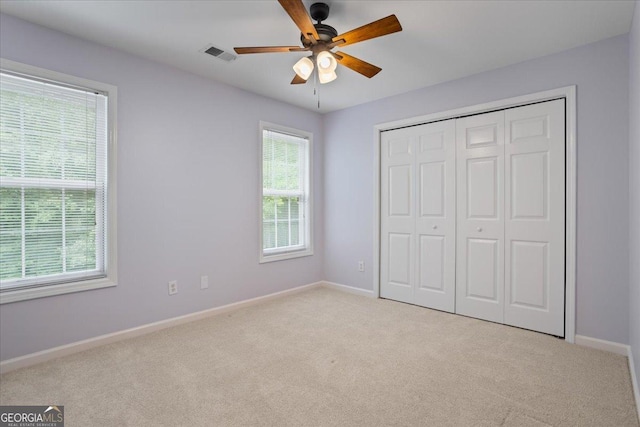 unfurnished bedroom with light carpet, baseboards, and a closet